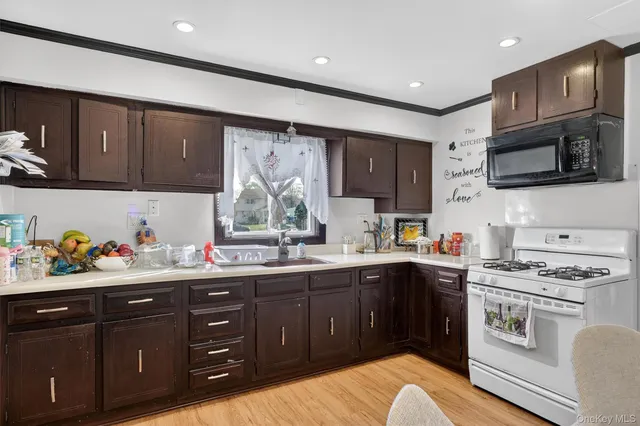 a kitchen with stainless steel appliances a stove top oven a sink dishwasher and cabinets
