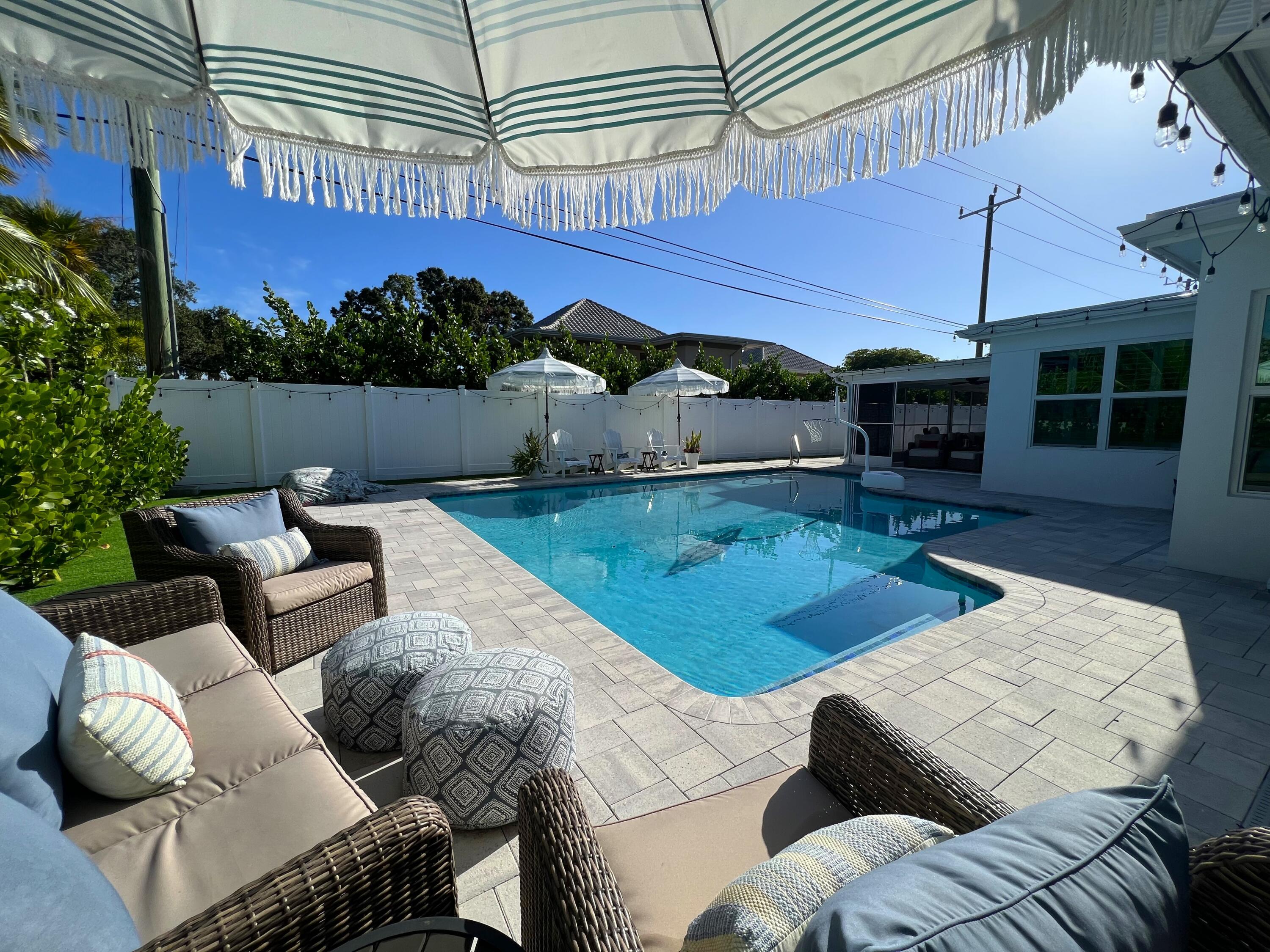 342 Country Club Drive Tequesta, FL 33469 - Photo 51 of 67 a view of a patio with couches and pool