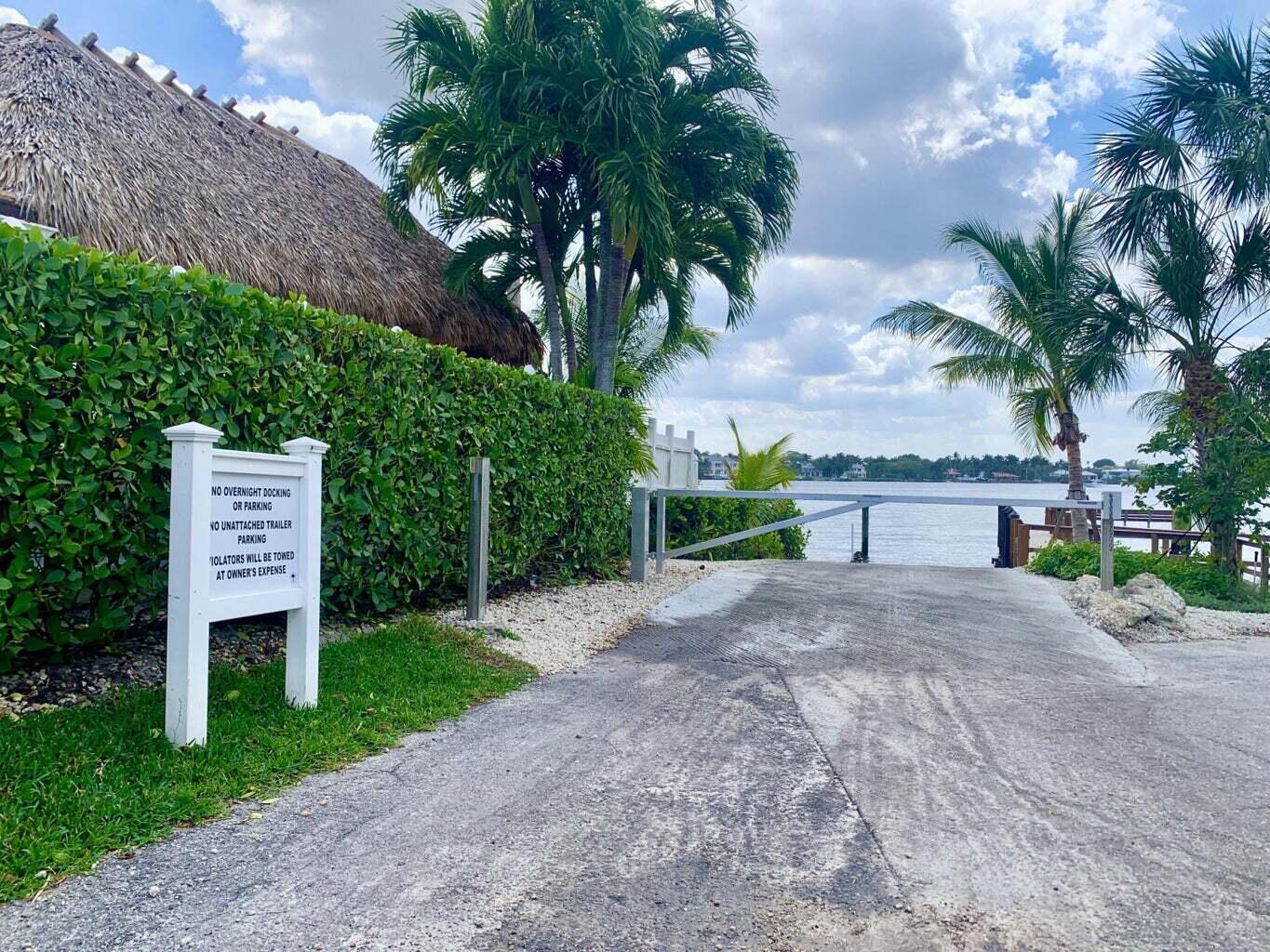 342 Country Club Drive Tequesta, FL 33469 - Photo 56 of 67 a front view of a house with a yard and a garage