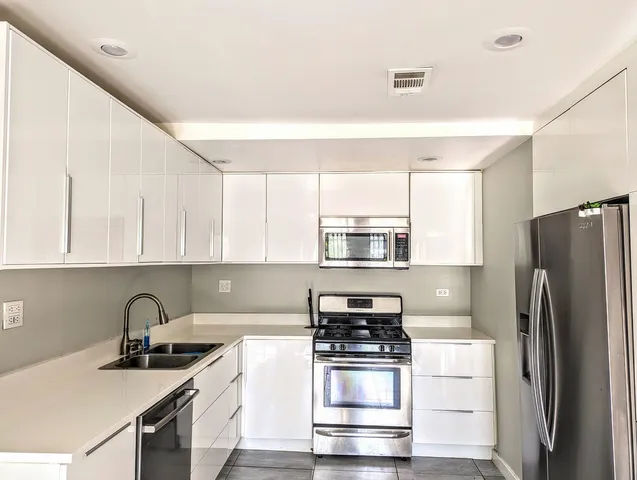 a kitchen with stainless steel appliances a stove sink and refrigerator