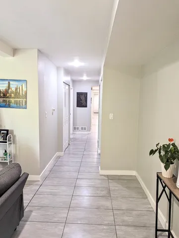 a view of hallway with furniture and wooden floor