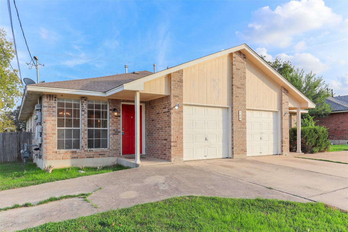View of front of property featuring concrete driveway, an attached garage, and brick siding