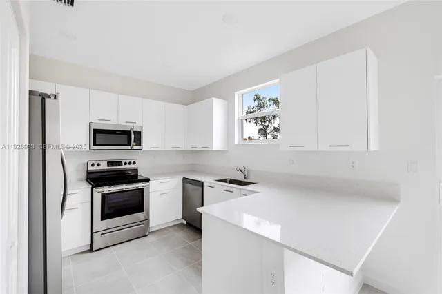 a kitchen with a sink stove and microwave