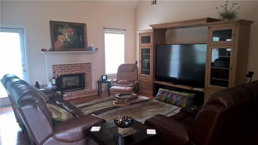 a living room with furniture a fireplace and a flat screen tv