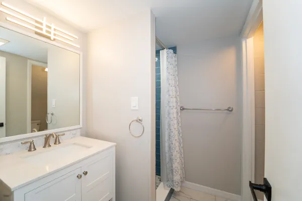 a white toilet sitting next to a shower