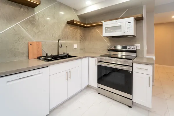 a kitchen with granite countertop a sink stove and refrigerator