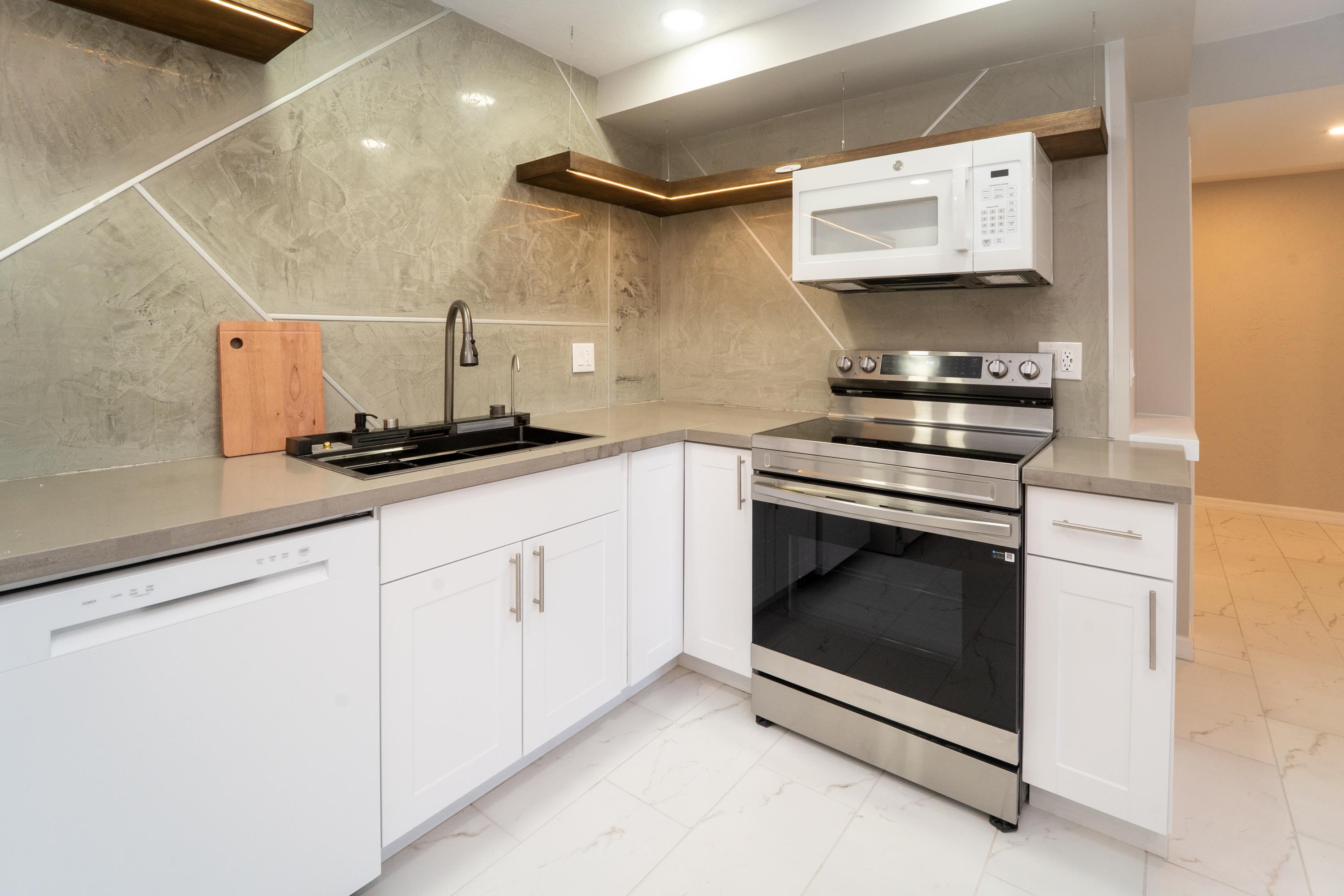 5455 Pelican Way, Unit B St. Augustine, FL 32080 - Photo 21 of 27 a kitchen with stainless steel appliances a stove a microwave and a sink