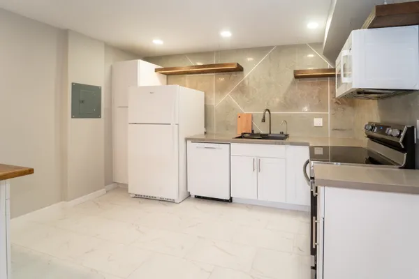 a kitchen with granite countertop a refrigerator and a stove top oven