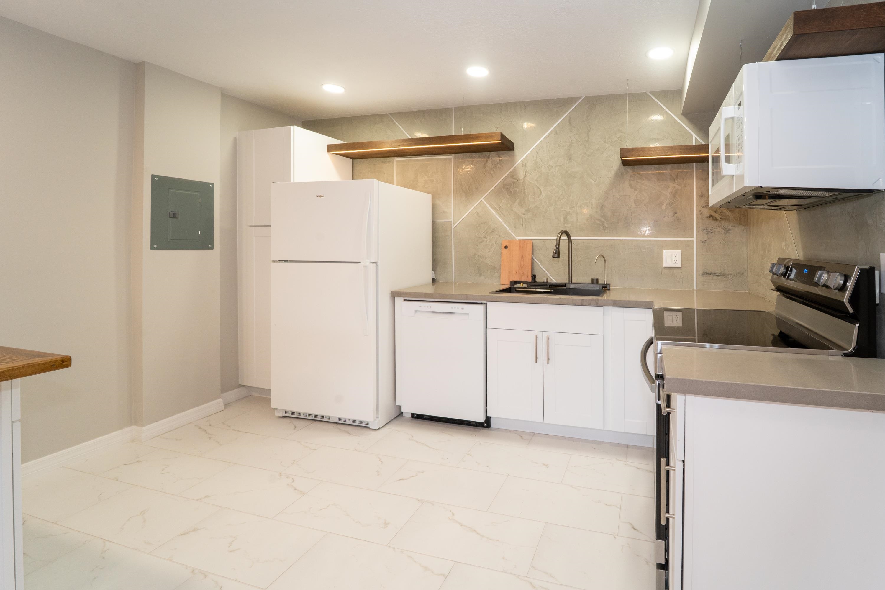 5455 Pelican Way, Unit B St. Augustine, FL 32080 - Photo 22 of 27 a kitchen with granite countertop a sink stove and refrigerator