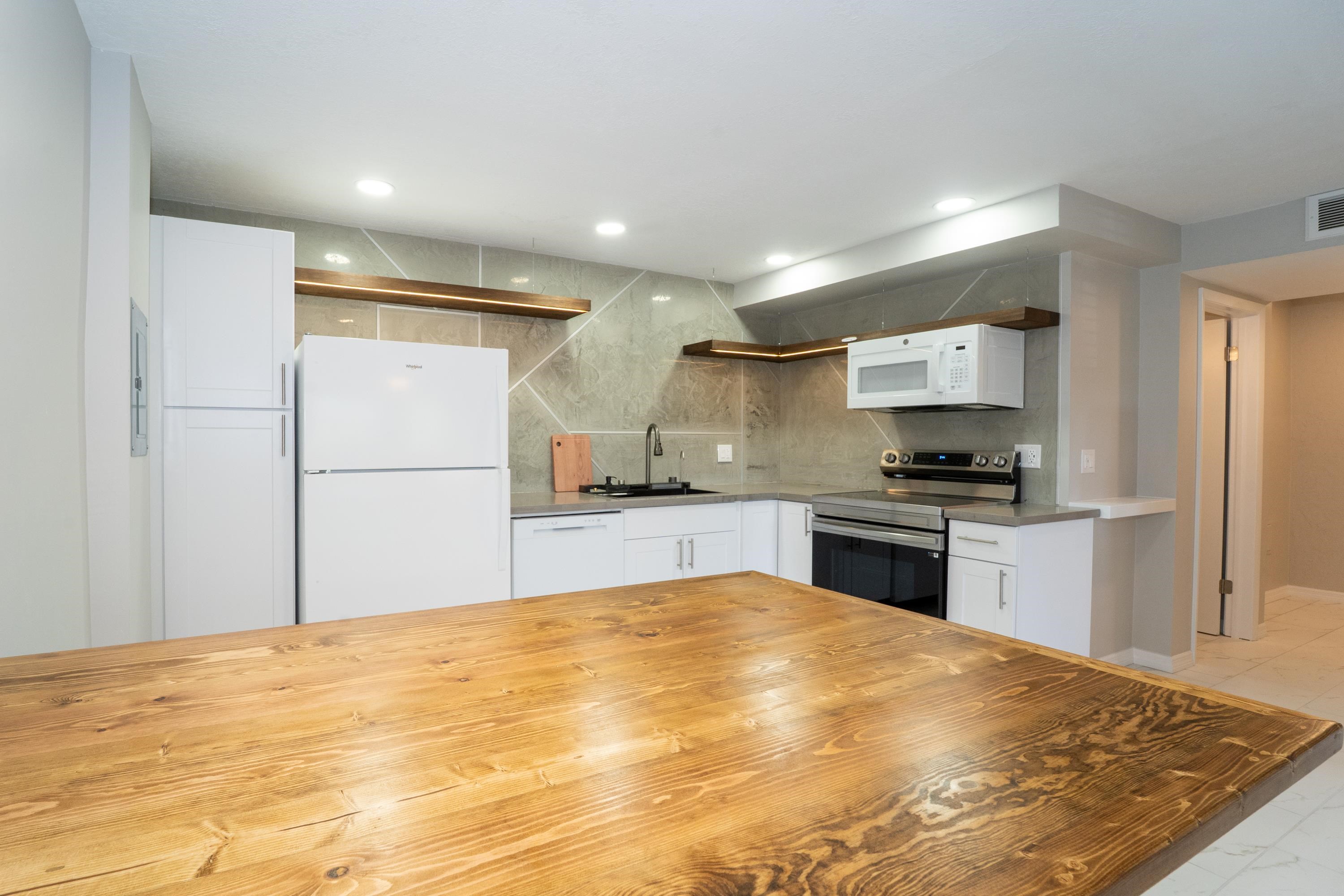 5455 Pelican Way, Unit B St. Augustine, FL 32080 - Photo 23 of 27 a kitchen with granite countertop a refrigerator and a stove top oven