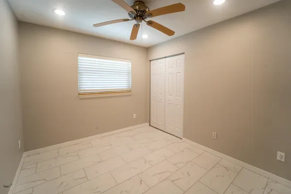 an empty room with fan and windows
