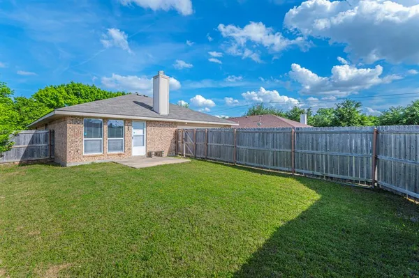 a view of a house with backyard and a tree
