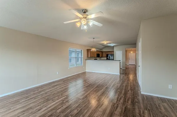 a view of a kitchen with wooden floor and a ceiling fan