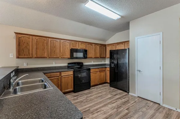 a kitchen with stainless steel appliances granite countertop a stove a sink and a refrigerator