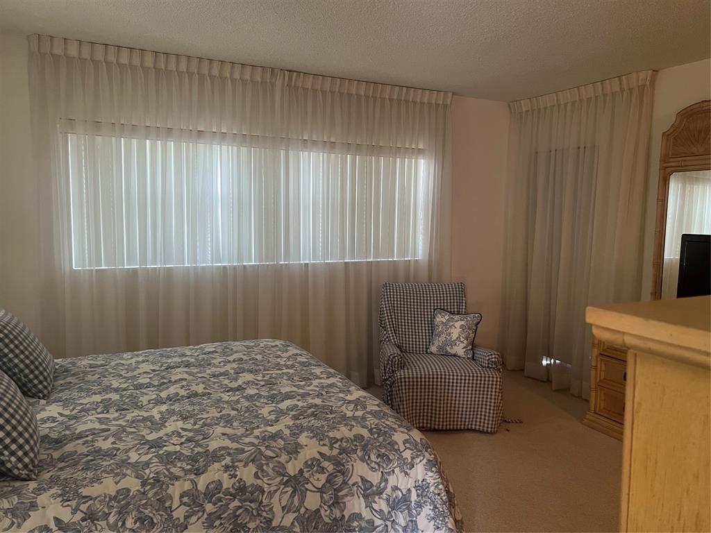 1425 Atlantic Shores Boulevard, Unit 601 Hallandale Beach, FL 33009 - Photo 13 of 23 a bedroom with a bed and a table chair