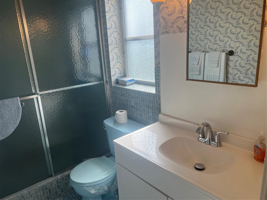 1425 Atlantic Shores Boulevard, Unit 601 Hallandale Beach, FL 33009 - Photo 21 of 23 a bathroom with a sink and mirror with toilet