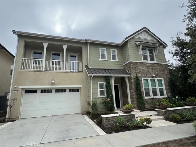 a front view of a house with yard and parking