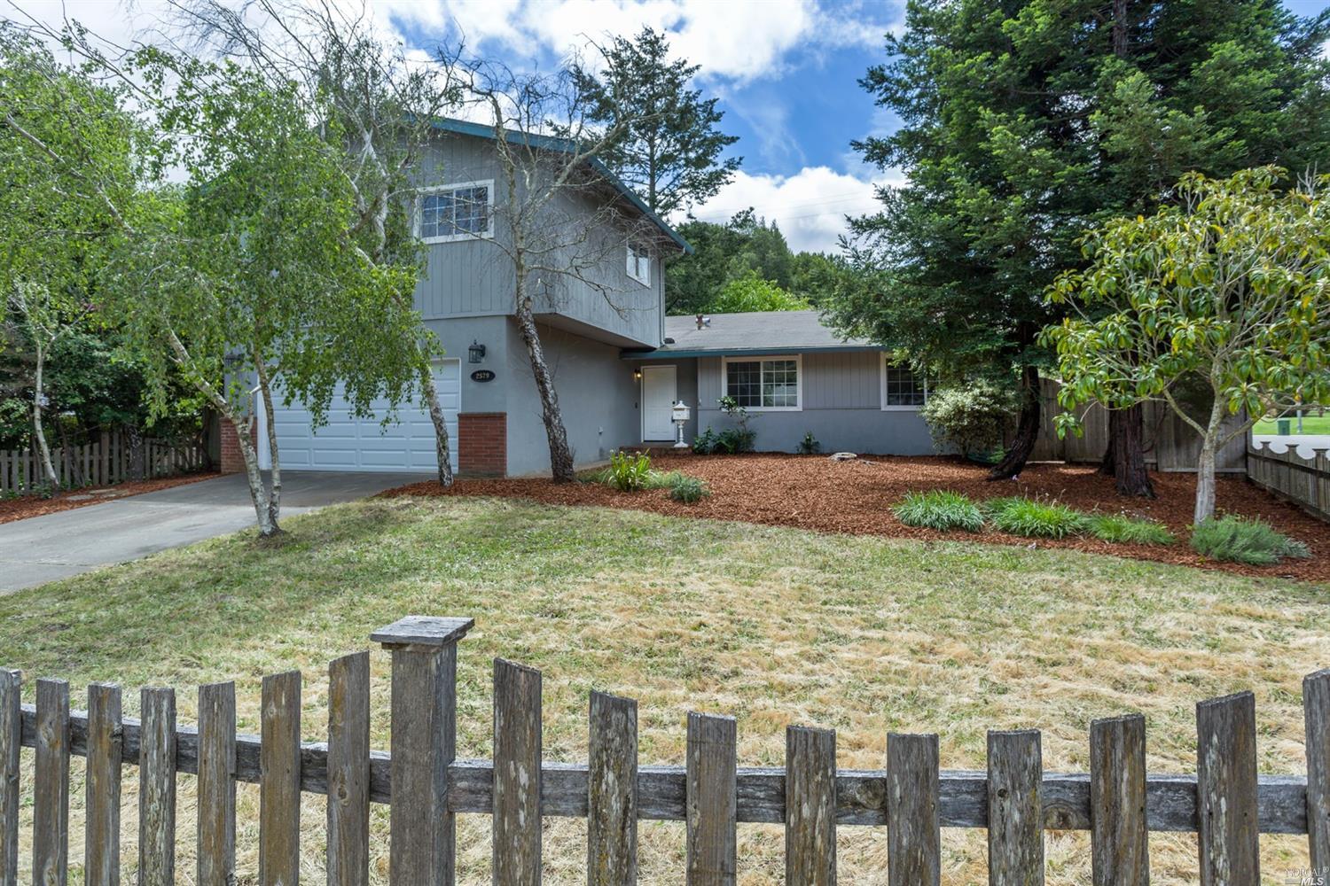 2579 Center Road Novato, CA 94947 - Photo 1 of 1 a backyard of a house with large trees and wooden fence