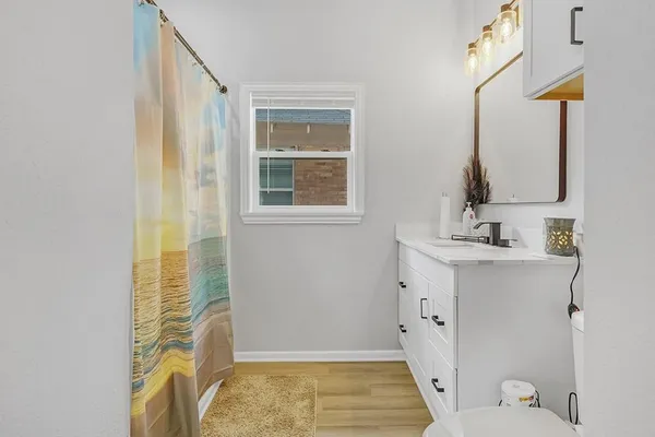 a bathroom with a sink a toilet and shower