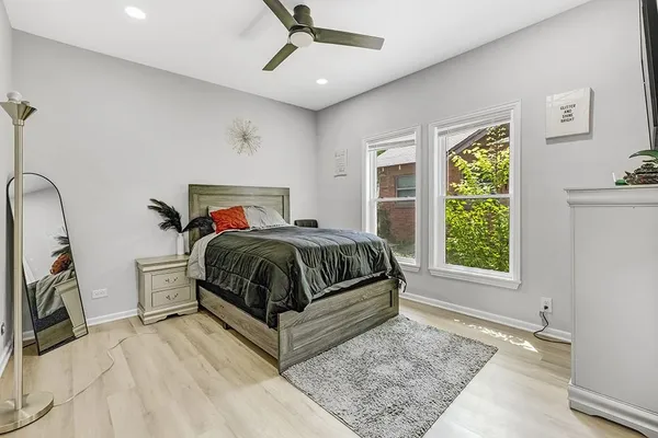 a bedroom with a bed and a dresser next to a window