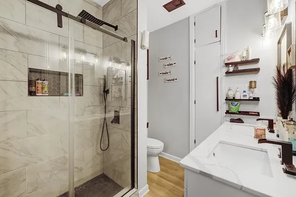 a bathroom with a sink a toilet and shower