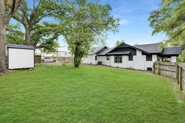 a front view of a house with a garden and trees