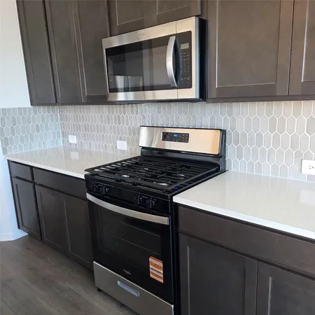 a kitchen with wooden cabinets and a stove top oven