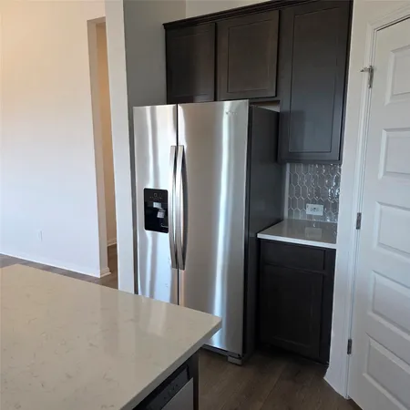a metallic refrigerator freezer sitting in a kitchen