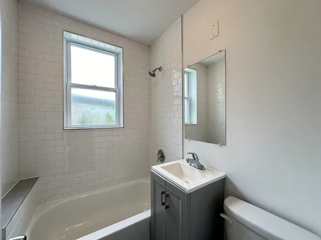 a bathroom with a sink and mirror with toilet