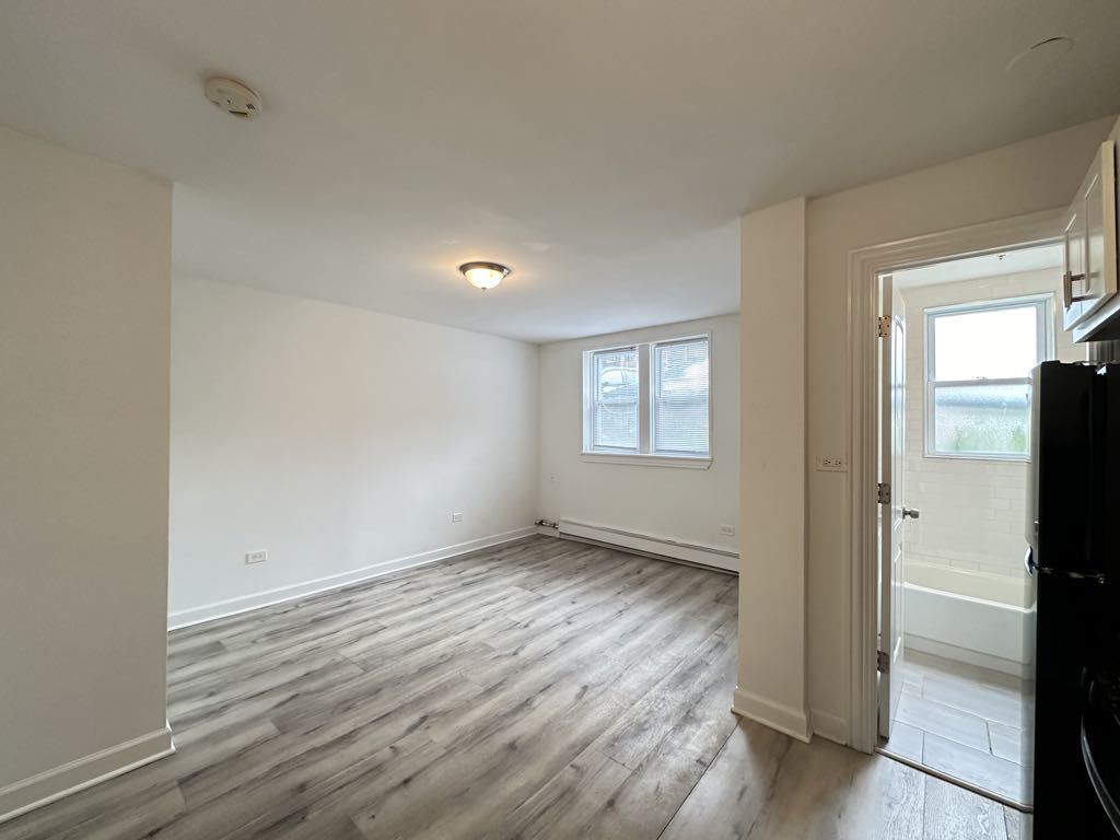5710 North Winthrop Avenue, Unit 113 Chicago, IL 60660 - Photo 5 of 20 an empty room with wooden floor and windows