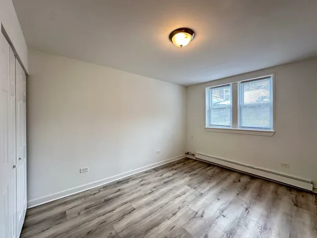 a view of a room with wooden floor and window