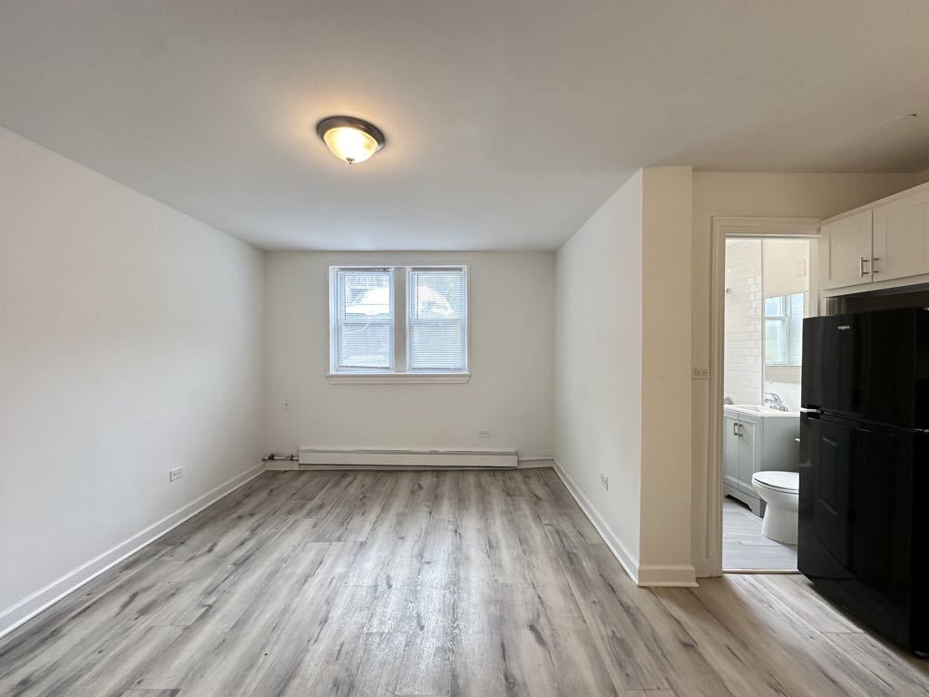 5710 North Winthrop Avenue, Unit 113 Chicago, IL 60660 - Photo 7 of 20 a view of a room with wooden floor and electronic appliances