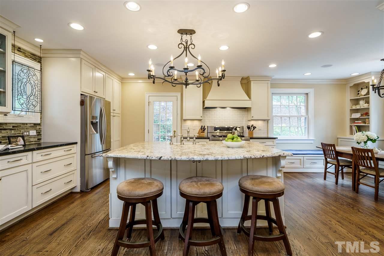 1501 St Marys Street Raleigh, NC 27608 - Photo 6 of 30 Oversized island for dining, farmhouse sink, double oven, soapstone counters, and access to the side yard for composting, gardening, and bird-watching.