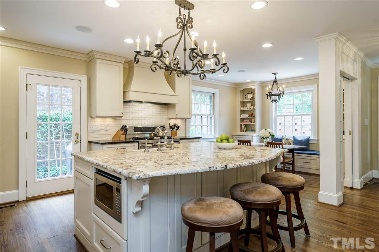 1501 St Marys Street Raleigh, NC 27608 - Photo 7 of 30 Share the heart of the home with cozy spaces and bench seating so others can gather around the table. Built-ins and cabinetry stylize the space. Notice the clever use of one of the home's original features (mirrored pocket doors to hide any kitchen mess).