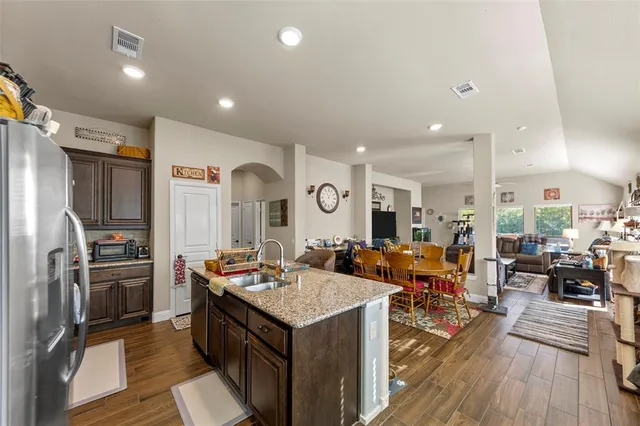a kitchen with granite countertop a sink appliances and cabinets