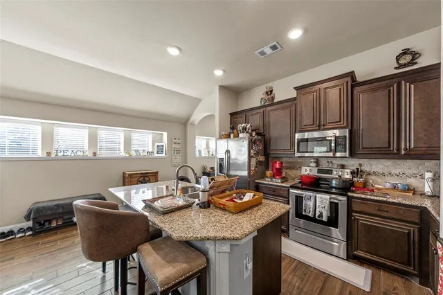 a large kitchen with a table and chairs