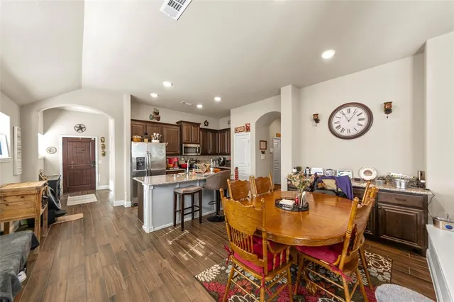 a view of a dining room with furniture a kitchen and chandelier