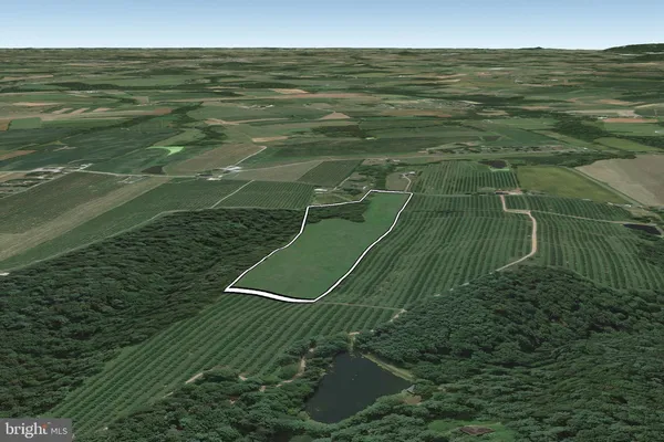 a view of a green field with wooden fence