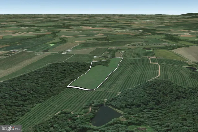 a view of a green field with wooden fence