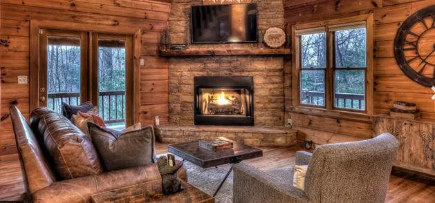 a living room with furniture a fireplace and a floor to ceiling window