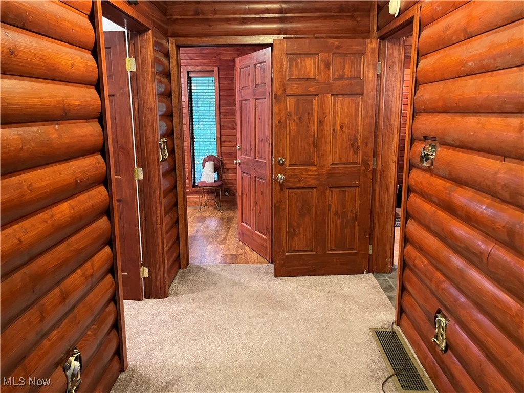 74068 Lake Ridge Road Piedmont, OH 43983 - Photo 26 of 45 Hall featuring light carpet and wooden walls