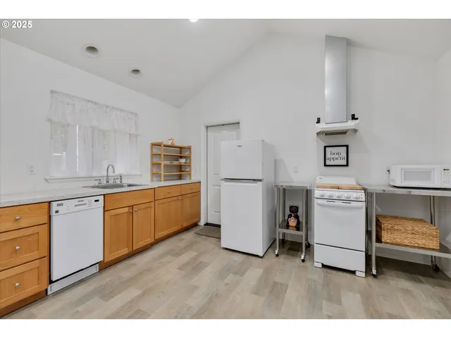 a kitchen with a refrigerator a stove top oven and a sink