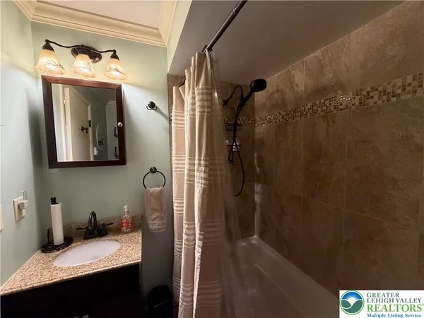 a bathroom with a sink and mirror with bathtub