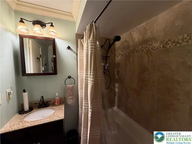 a bathroom with a sink and mirror with bathtub