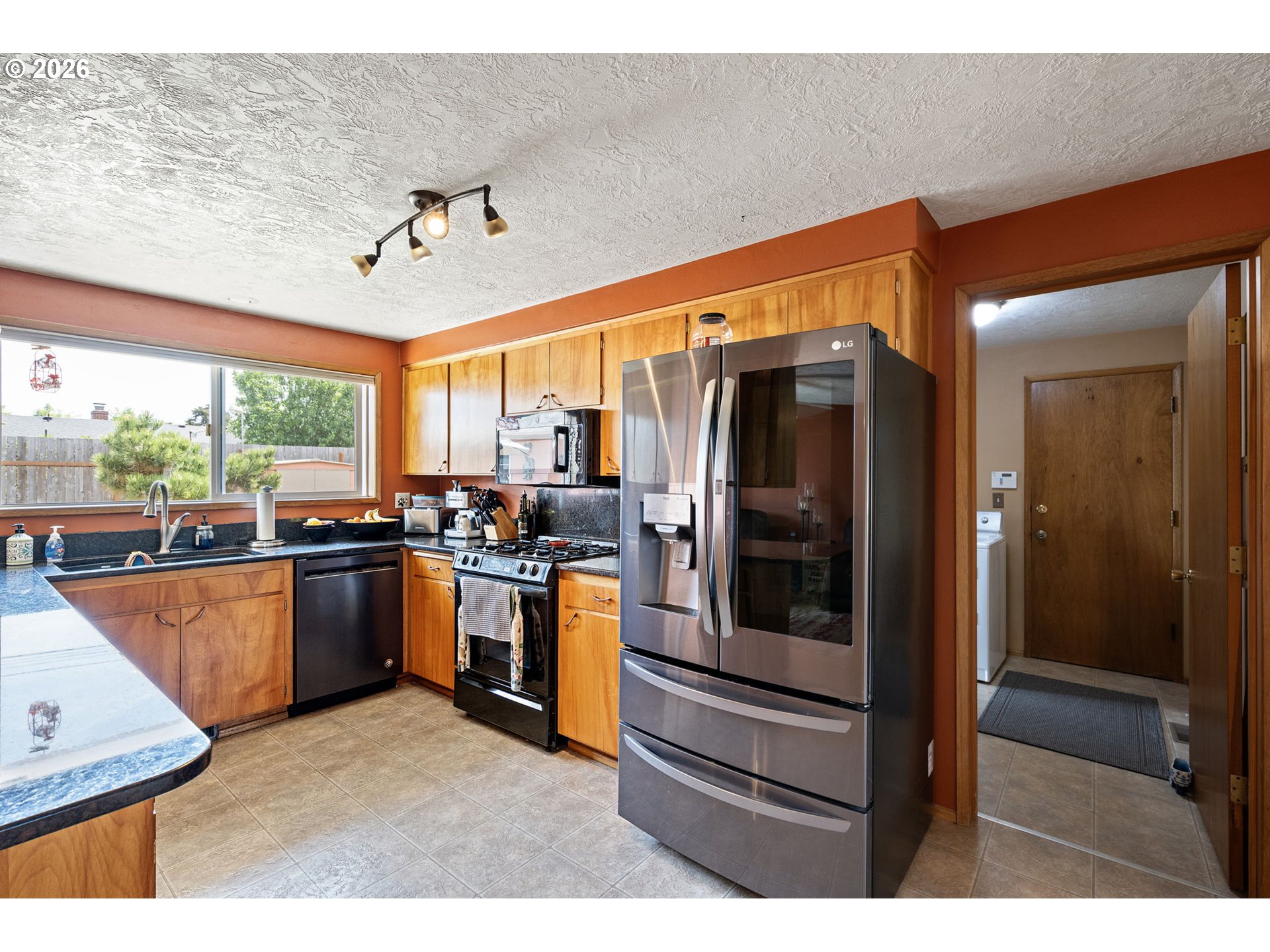 2465 17th Street Springfield, OR 97477 - Photo 14 of 47 a kitchen with stainless steel appliances kitchen island granite countertop a refrigerator and cabinets