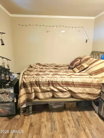 a view of a bedroom with wooden floor