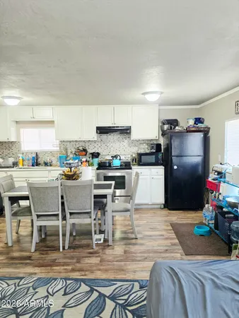 a kitchen with stainless steel appliances kitchen island granite countertop a refrigerator a stove a sink a dining table and chairs