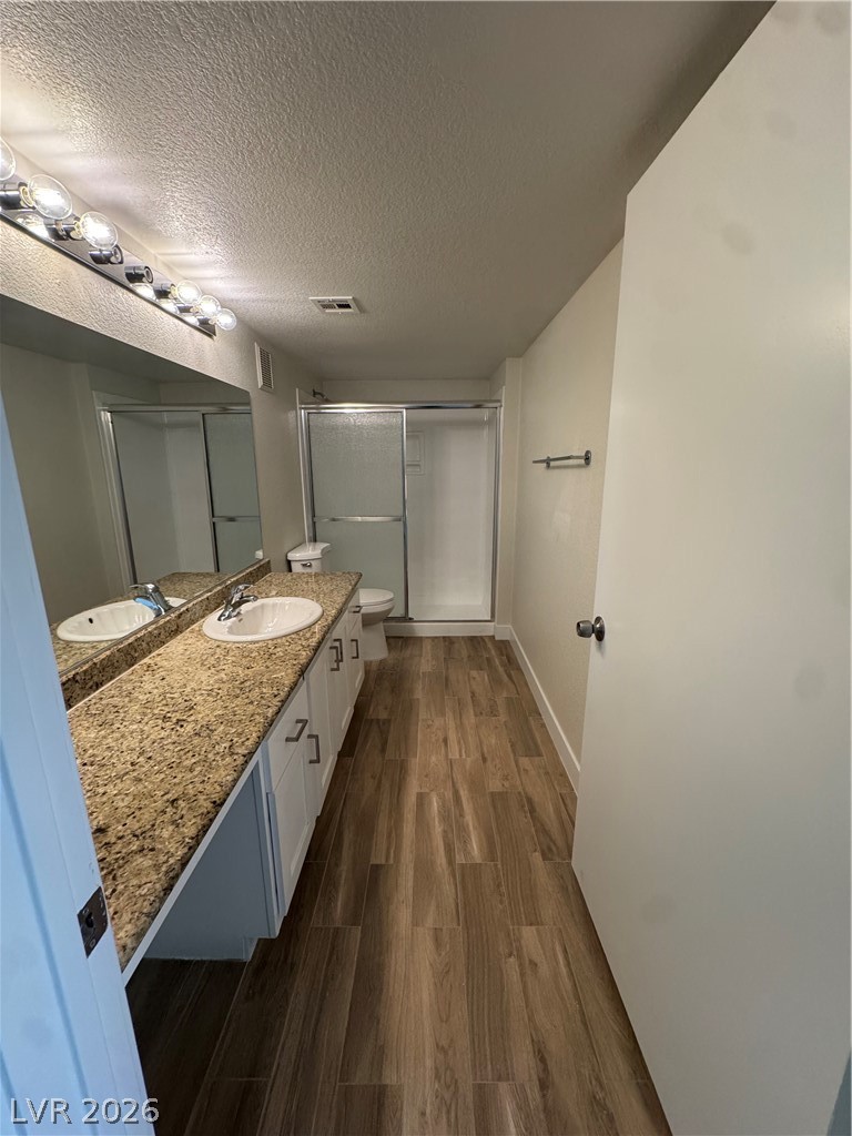 8101 West Flamingo Road, Unit 1040 Las Vegas, NV 89147 - Photo 14 of 22 This primary bathroom features a double vanity with granite counters and a glass-enclosed shower.