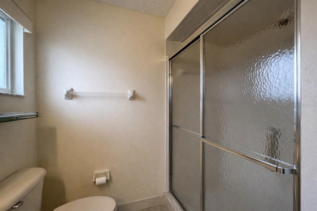 11268 Southwest 75th Terrace Ocala, FL 34476 - Photo 16 of 32 a bathroom with a granite countertop toilet and a shower