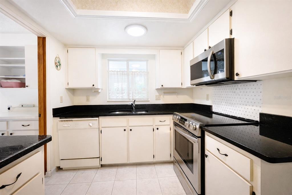 11268 Southwest 75th Terrace Ocala, FL 34476 - Photo 21 of 32 a kitchen with stainless steel appliances granite countertop a sink and a stove